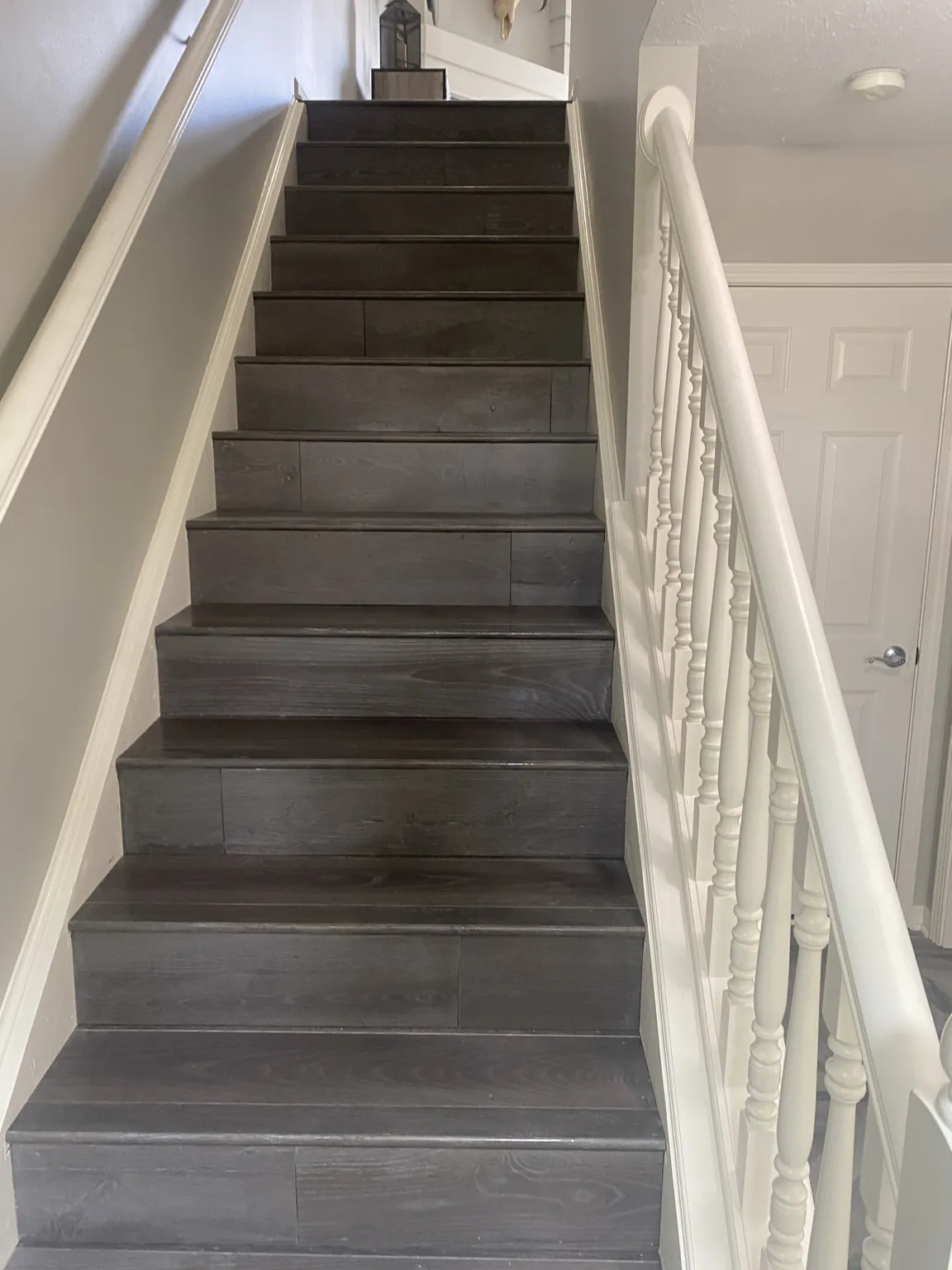 Dark finished staircase with white painted trim and railing
